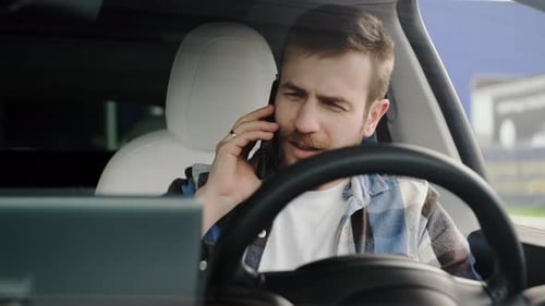 Young Man Talking on Phone in Car