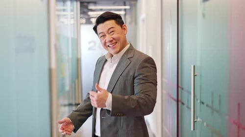 Happy Male Doing Welcoming Gesture and Inviting Employers to Modern Office