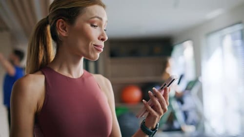 Sporty Girl Looking Smartphone in Fitness Center Closeup Fit Woman Tracking