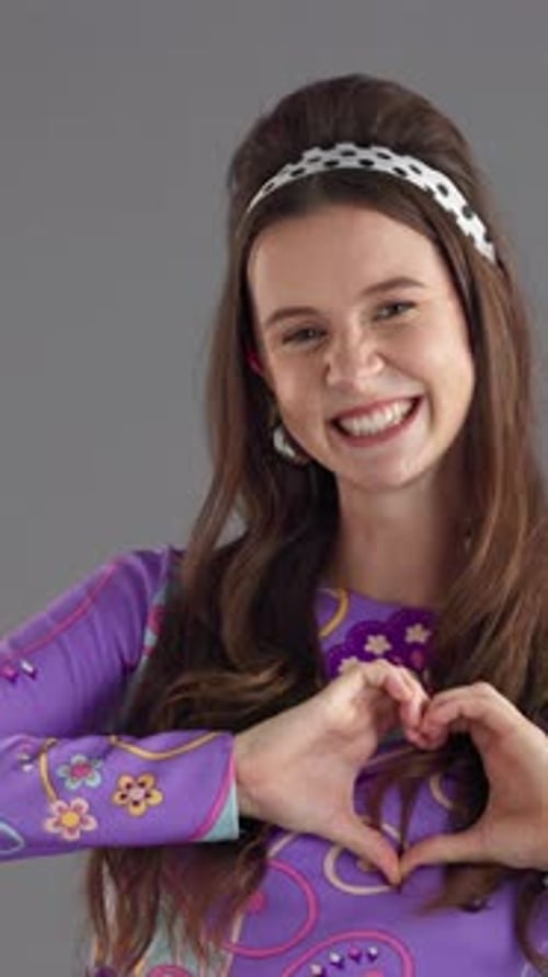 Happy, heart hands and face of woman in studio with kindness, support or care gesture