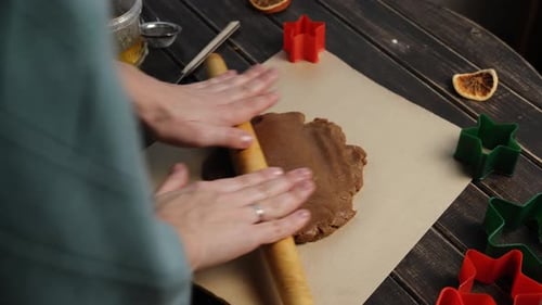 Une femme déroule la pâte pour les biscuits au pain d'épice de Noël