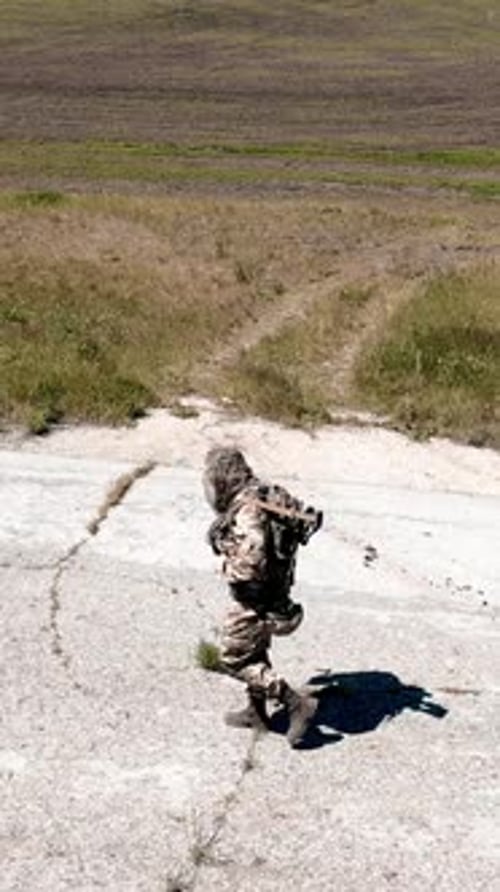Aerial View of a Lonely Soldier Walks Along an Old Concrete Road