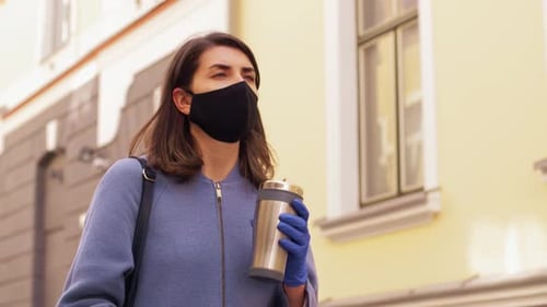 Woman Wearing Mask and Gloves Holds Coffee Cup
