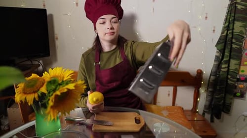 Woman Sitting at Kitchen Table is Going to Grate Lemon Zest Using Metal Utensil