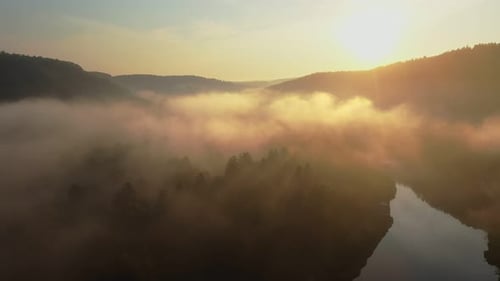 Sunlight Bathing a Foggy River Valley in a Tranquil Morning Scene