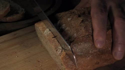 Bread Slicing with Knife on Wooden Board