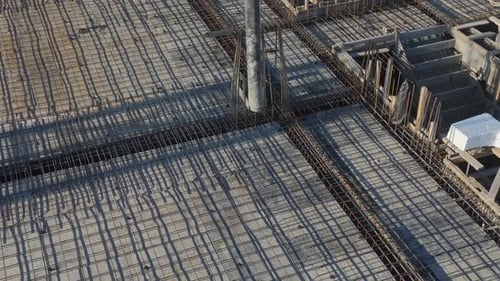 Aerial Video Cranes Lifting Heavy Loads on a Construction Site With Workers Handling Concrete and