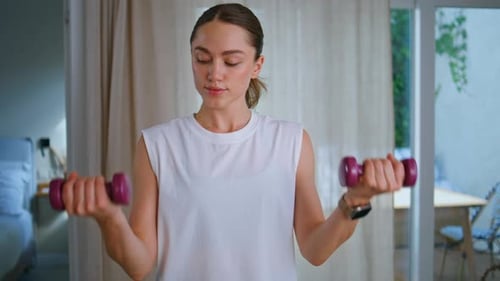 Woman Lifting Dumbbells During Indoor Workout