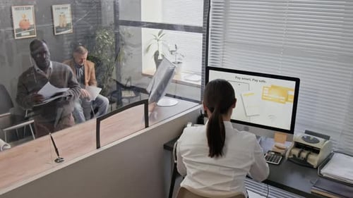 Teller Assisting Elderly Customer Holding Documents at Bank Office