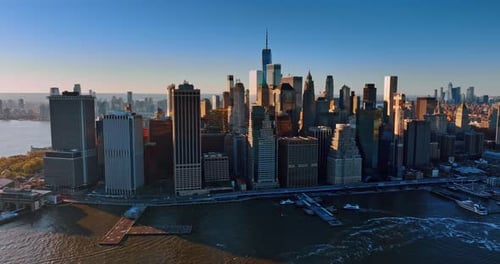 Modern Manhattan lit with bright light at sunset. Drone approaches the architecture of New York