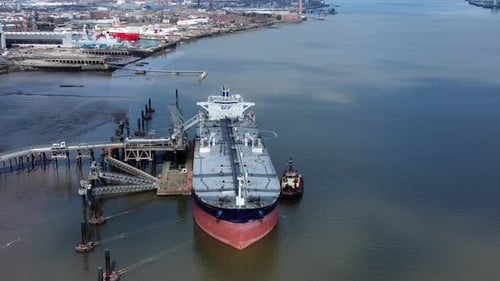 Crude oil tanker ship loading at refinery harbour terminal aerial high angle view