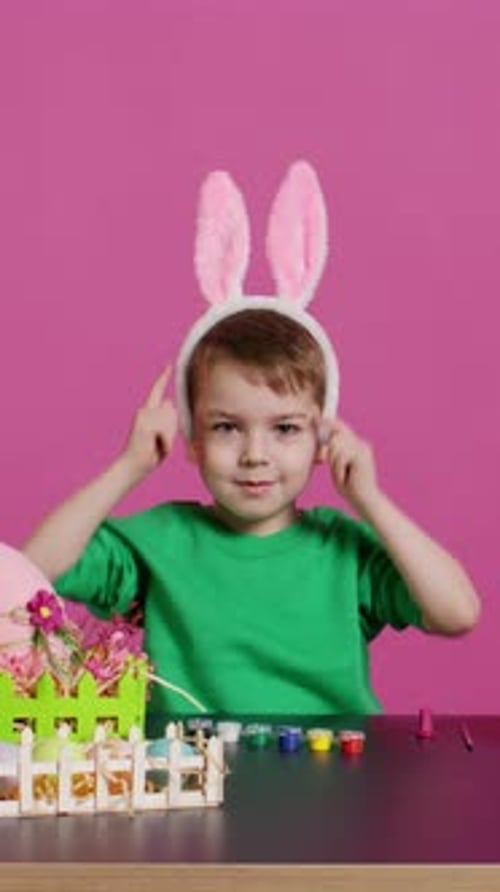 Sweet Little Child Putting Fluffy Bunny Ears on His Head and Smiling on Camera