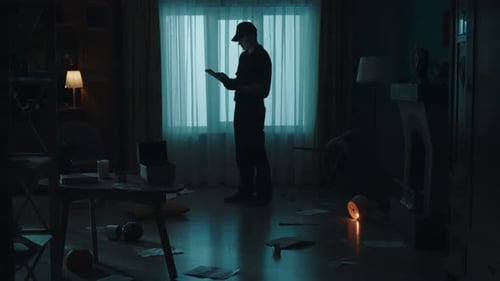 Figure Reads Tablet in Chaotic Room