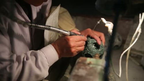 Factory worker skillfully carves a jade sculpture in Beijing China