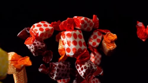 Colorful Wrapped Candies Floating on Black