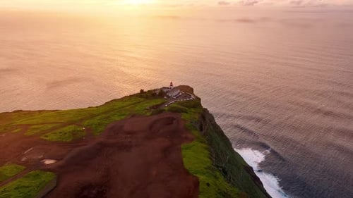 Explore the stunning coastline and lighthouse at sunset from above