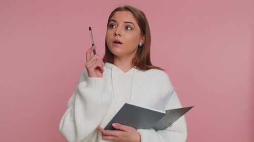Woman Thinks and Writes Idea in Notebook