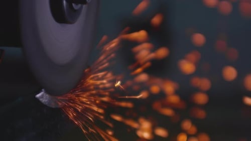 Grinder Cuts Metal Sending Sparks Flying in Dark Workshop