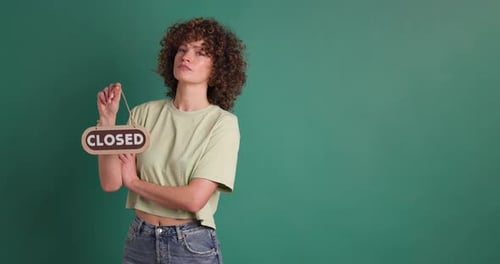 Frau mit geschlossenem Schild auf grünem Hintergrund