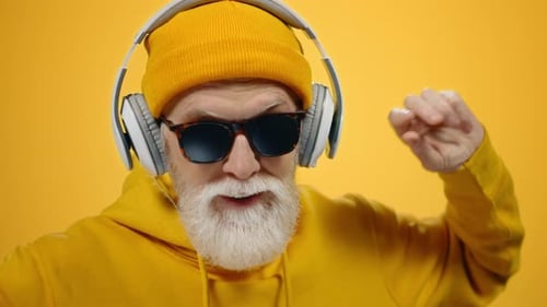 Senior Man Dancing with Headphones and Sunglasses
