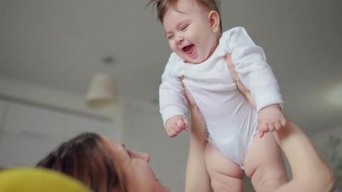 Loving Parent Holding Laughing Baby in Air