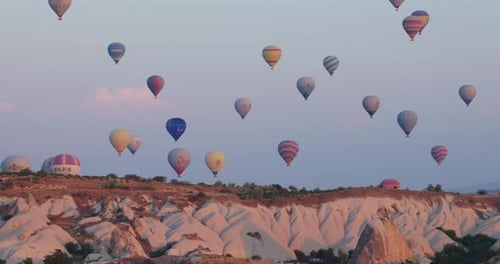 Pan-right view of hot air balloons flying over Cappadocia, Turkey