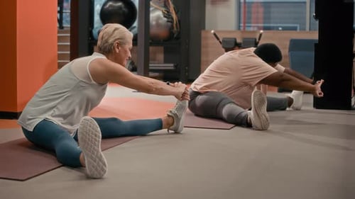 Diverse Senior Women in Sportswear Stretching Legs during Fitness Training