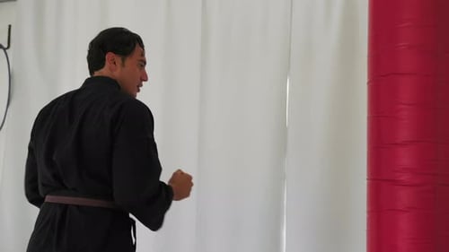 Man Practicing Punches in Martial Arts Uniform