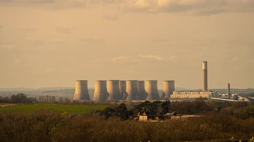 Nuclear Power Plant Cooling Towers and Chimney Over Countryside at Sunset Energy Production and