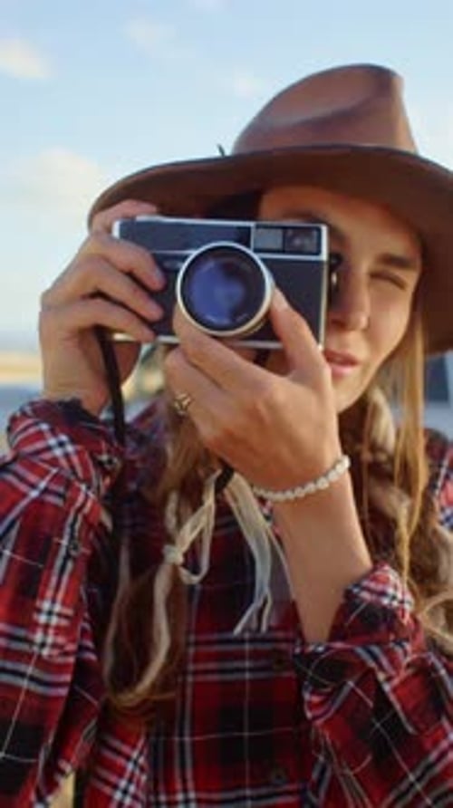Photographer Taking Pictures with Vintage Camera in a Field at Sunset