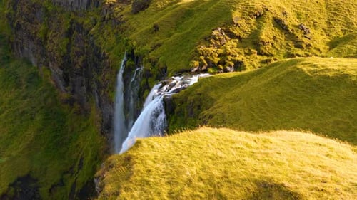 Aerial View of Scenic Waterfall Flowing Down Cliff
