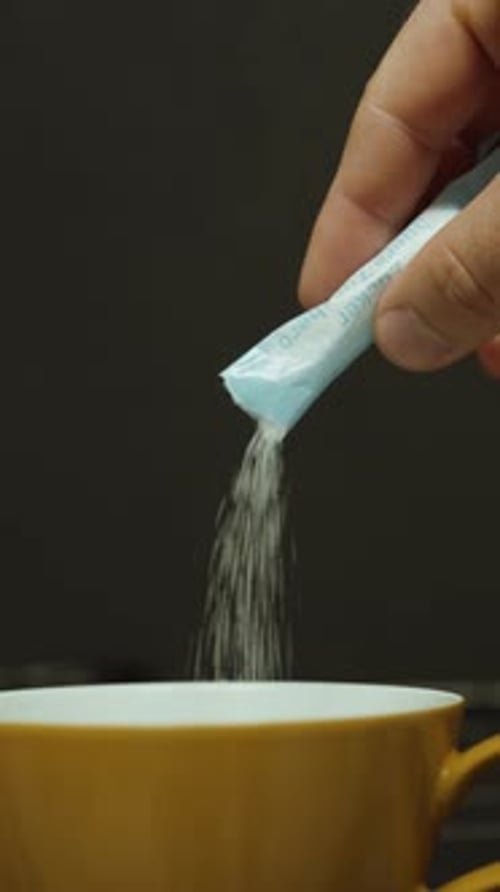 Sugar being poured into cup