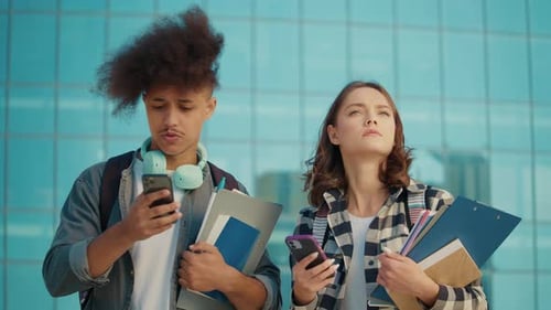 Two Attractive Students Surch Something and Using Smartphone at University Yard