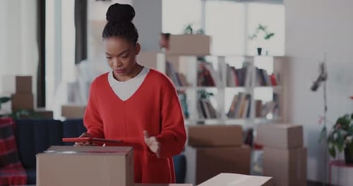 Woman Uses Tablet While Moving House