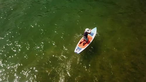 Top down aerial view of woman on paddleboard