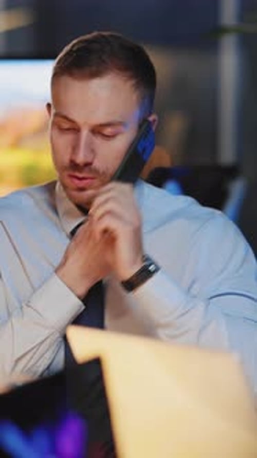 Man Talking on Phone in Modern Office at Night