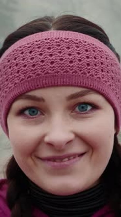 Portrait of woman in headband looking at camera and smiling. Vertical video