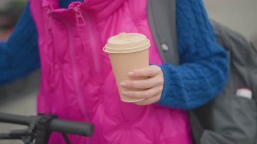 Woman Carrying Coffee Bottle Beside Her Bicycle in Morning City Female Individual Holding Takeout