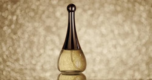 Frasco de perfume elegante contra fundo dourado cintilante