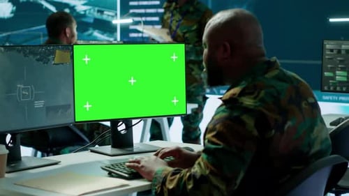 Soldier Analyzing Real Time Data Next to Green Screen in High Tech Office