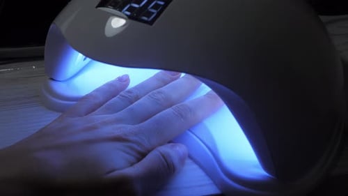 Hand Receiving Gel Manicure Under UV Light
