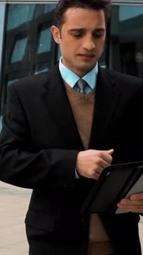 Professional Man Smiles While Using Tablet Outdoors