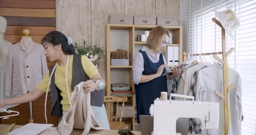 Two Women Work on Fashion Designs in Studio