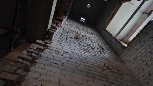 Inside the long shaft of old brick walls. Low angle view at the elevator pit in the shabby building.