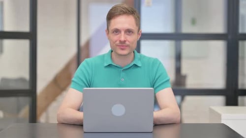 Man Gives Thumbs Up at Desk