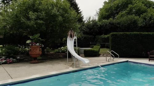 Boy Going Down Water Slide Into Pool Slow Motion