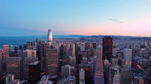 Aerial video approaching towards down town, revealing the city view and the towns behind.