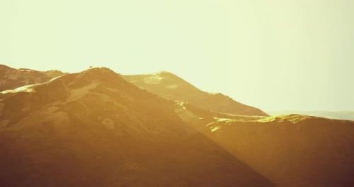 Soleil chaud illuminant de douces collines dans un paysage serein au crépuscule