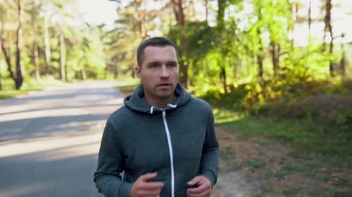 A Man in a Park or Forest Runs in the Street