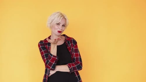 Woman with Blonde Hair Blowing a Kiss